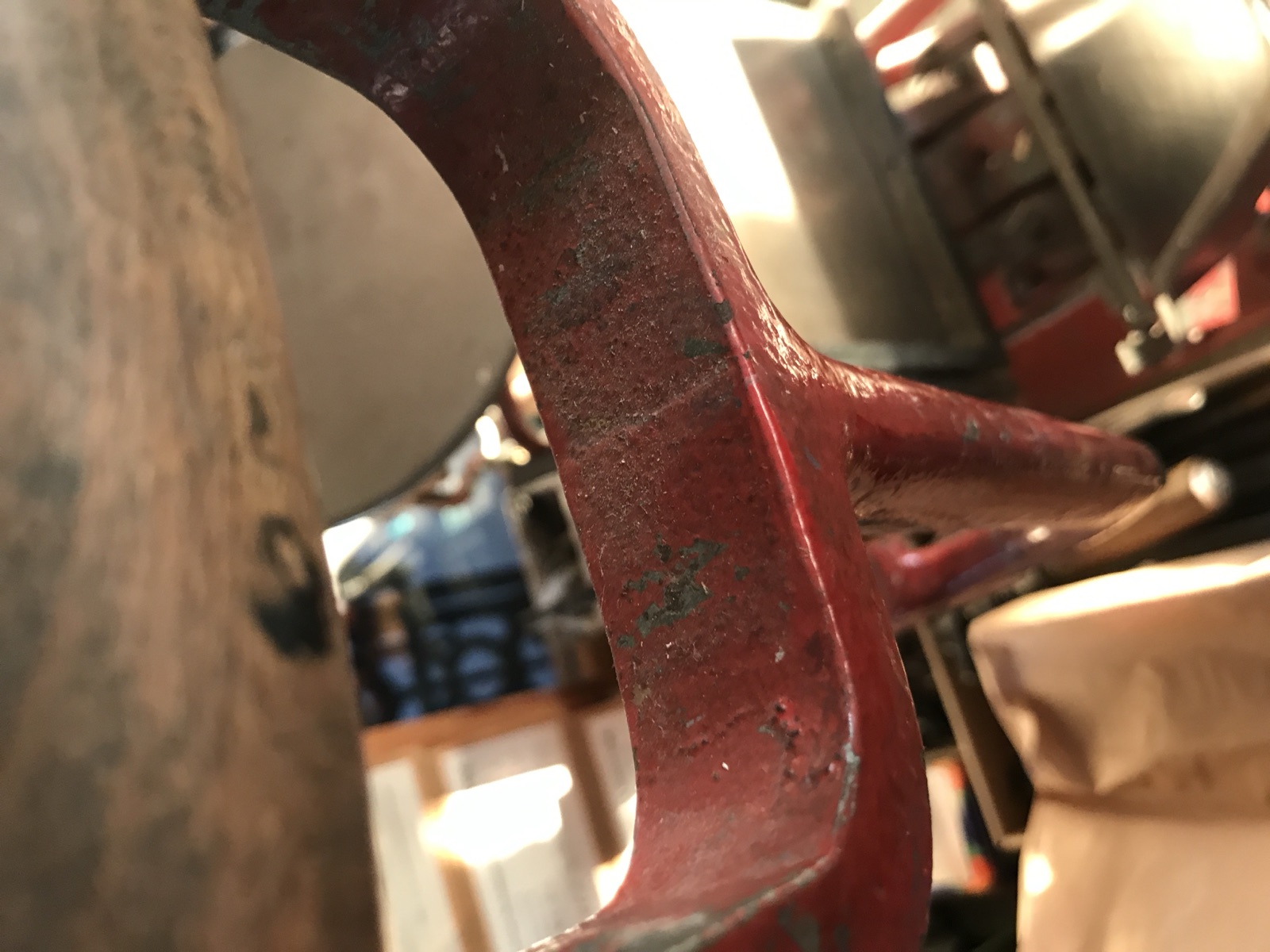 Abblätternde rote Lackierung am Gussrahmen des Tiegels